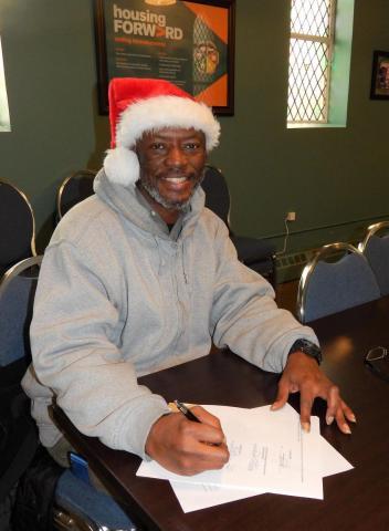 man with santa hat signing papers