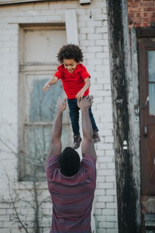 father tossing child in the air