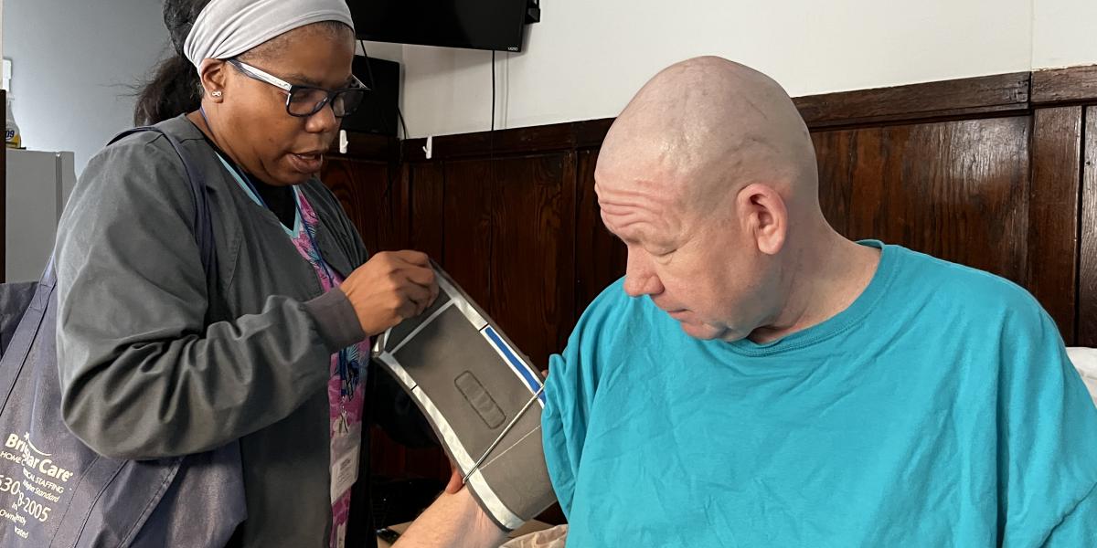 Community health nurse taking client's blood pressure