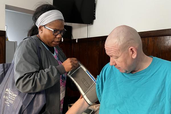 Community health nurse taking client's blood pressure