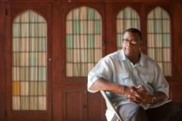 man sitting in front of windows