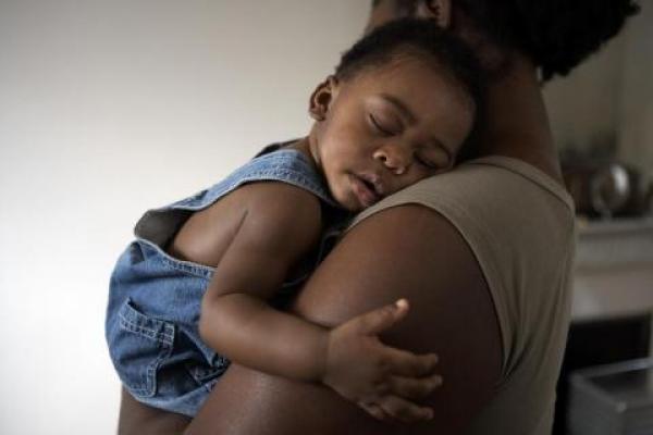 baby sleeping in woman's arms