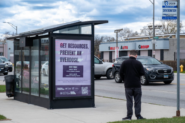Screenshot 2025-04-24 123925.png a man stands next to a bus advertisement